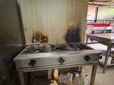 a kitchen with a stove top and a bunch of food on the counter