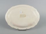 underside view of a white plate with writing on it on a gray surface