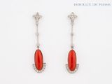 a pair of coral and diamond earrings