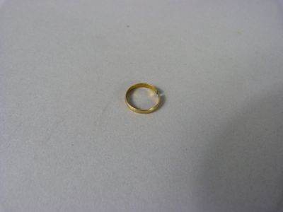 gros plan d'une bague en or sur une surface blanche