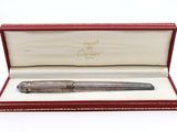 un stylo argenté dans un coffret rouge orné d'une bordure dorée