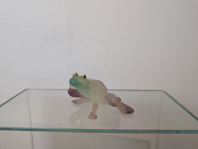 a glass table with a frog figurine on top of it