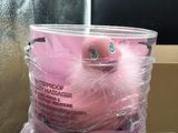 a pink stuffed animal that is wrapped in plastic