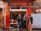 deux hommes debout devant un restaurant, avec un vélo