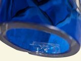 a close up of a blue glass vase with a diamond in it