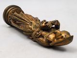 an antique bronze figurine of a woman laying on her stomach