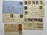 several old envelopes with stamps are on a white surface