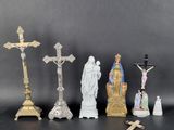 several figurines of jesus and other religious objects on a table