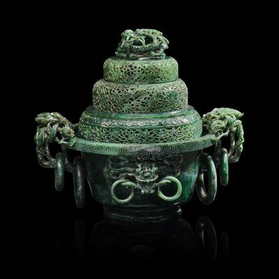 un gros plan d'un vase vert posé sur une surface noire