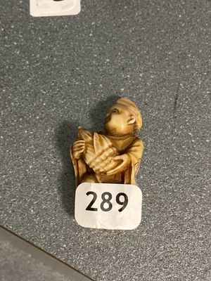une petite figurine représentant un singe assis sur une chaise