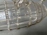 a glass vase with a chain around it on a table
