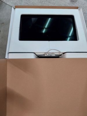 une boîte posée par terre, contenant un ordinateur