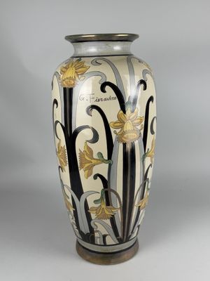 a vase with a floral design on it sitting on a table