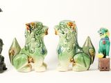 five figurines of animals sitting next to each other on a white surface