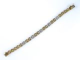 a close up of a gold and silver bracelet on a white background