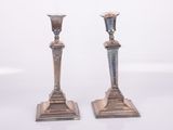 pair of antique silver candlesticks on a white background