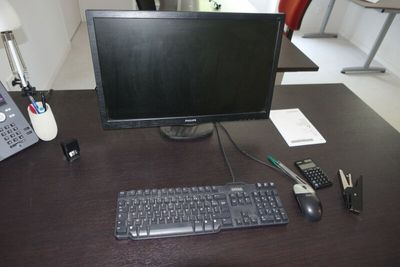 un écran d'ordinateur, un clavier et un téléphone posés sur un bureau