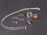 un collier, une bague, un bracelet et d'autres bijoux posés sur une table