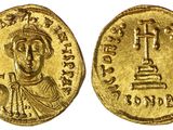 une pièce d'or avec l'image d'un homme tenant une croix