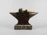 marble anvil with a hammer on top of it on a white background