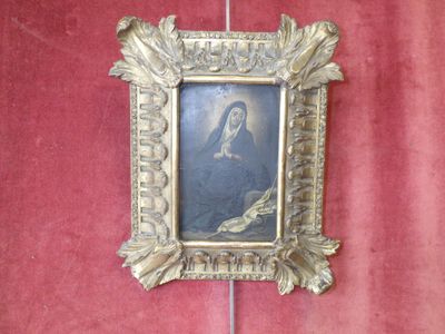 a picture of a woman in a gold frame on a red wall