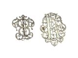 deux broches en argent ornées d'un monogramme au centre
