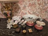 une table sur laquelle se trouvent une lampe, un bol, une assiette et d'autres objets