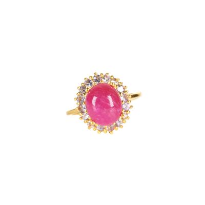 un gros plan d'une bague en pierre rose sur fond blanc