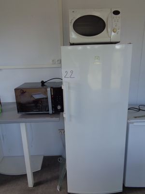 a white refrigerator and a microwave in a small kitchen