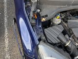 a blue car with its hood open on the side of the road