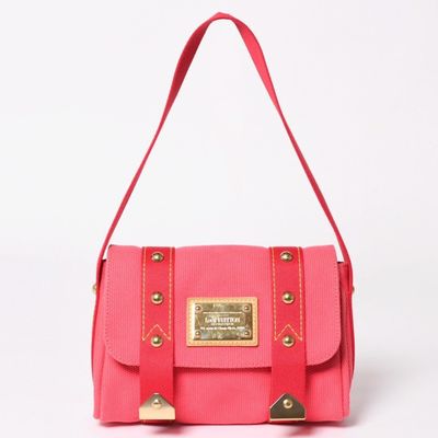 the small pink bag is sitting on a white surface