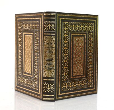 un livre noir et doré posé sur une surface blanche