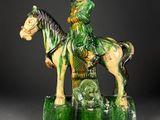 statue of a man sitting on a horse with a green background
