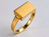gros plan d'une bague en or sur une surface blanche