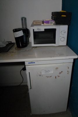 a microwave sitting on top of a small white refrigerator