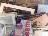 a pile of old picture frames and pictures on the floor