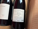 two bottles of wine sitting in a box on a table