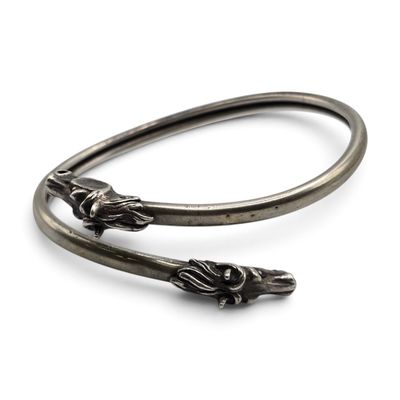 une photo représentant une paire de bracelets en argent posés sur une surface blanche