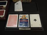 playing cards in a case sitting on a table next to a purse