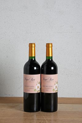 two bottles of wine sitting on top of a wooden table