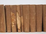 plusieurs vieux livres sont alignés sur une surface blanche