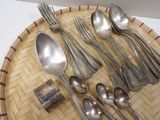 several spoons, forks, and spoon rest on a woven tray