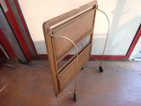 a small wooden table with wheels on the floor