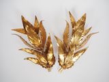 pair of gold leaf wall sculptures on a white surface