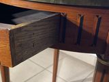 a small table with a drawer underneath it on a tiled floor