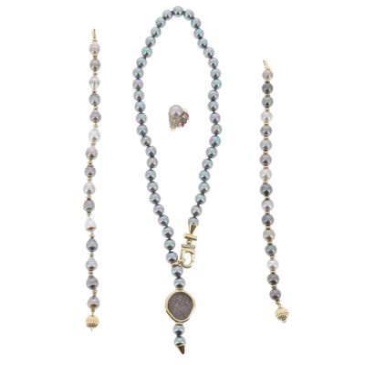 un gros plan d'un collier et d'une paire de boucles d'oreilles sur fond blanc