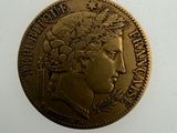 an old gold coin with a woman ' s head on it