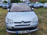 a silver citrole parked in a parking lot with other cars