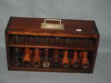 a wooden display case with several different types of pipes in it