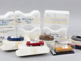 Plusieurs petites voitures sont alignées dans une vitrine posée sur une table